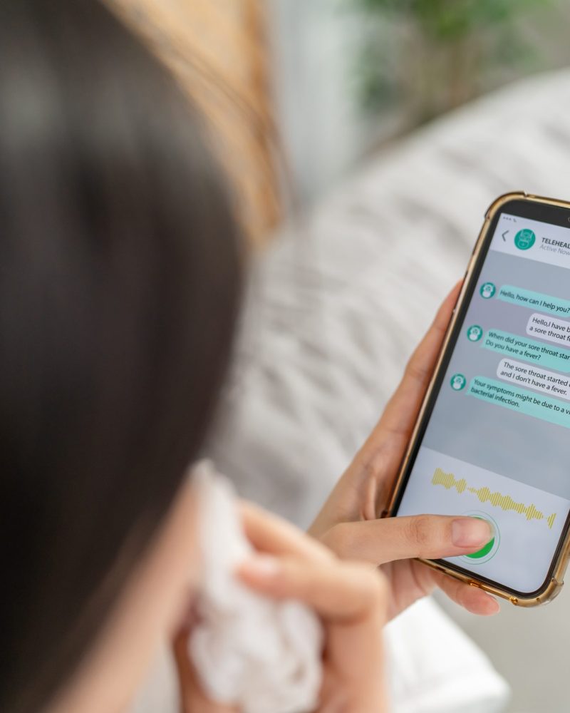 Close up of woman patient using phone apps consulting doctor online. Attractive female holding smartphone device sending text message and chatting remote for telemedicine telehealth treatment at home.